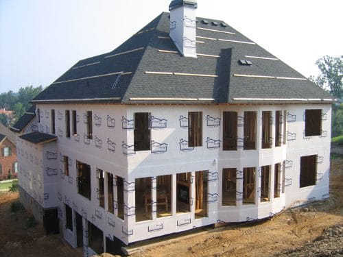House under construction wrapped with weather-resistant house wrap before siding installation